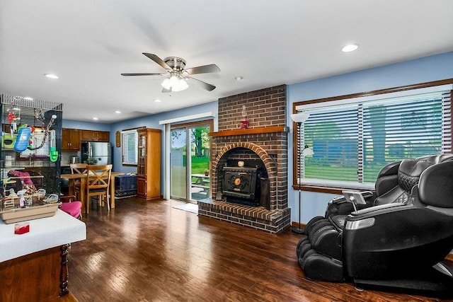 living room with a ceiling fan, wood finished floors, recessed lighting, and a wood stove