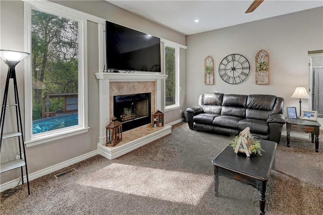 carpeted living area with recessed lighting, baseboards, visible vents, and a tiled fireplace