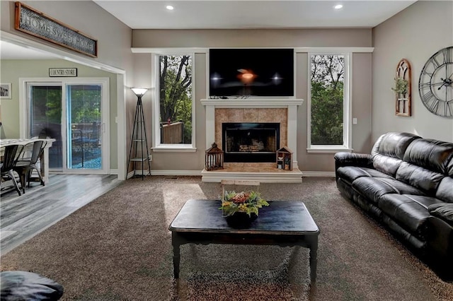 living area featuring carpet flooring, recessed lighting, baseboards, and a tile fireplace
