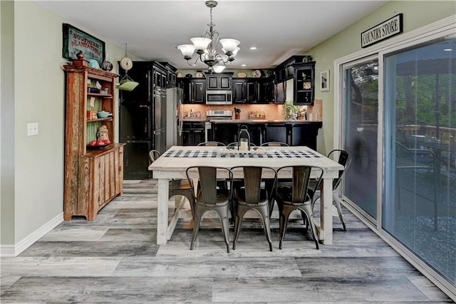 dining area featuring recessed lighting, baseboards, light wood finished floors, and a chandelier
