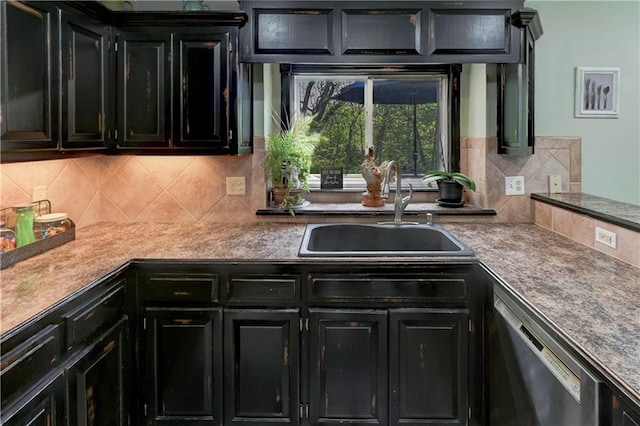 kitchen featuring a sink, dark cabinetry, backsplash, and dishwasher