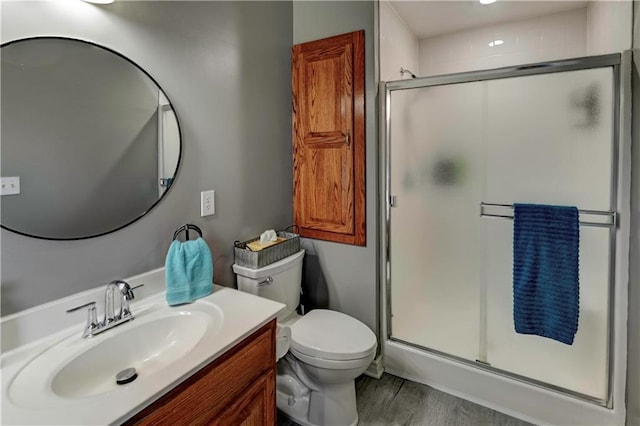 full bath with vanity, a shower stall, toilet, and wood finished floors