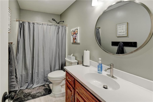 bathroom with vanity, a shower with shower curtain, and toilet