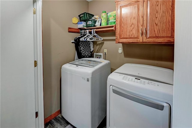 washroom with washing machine and clothes dryer and cabinet space