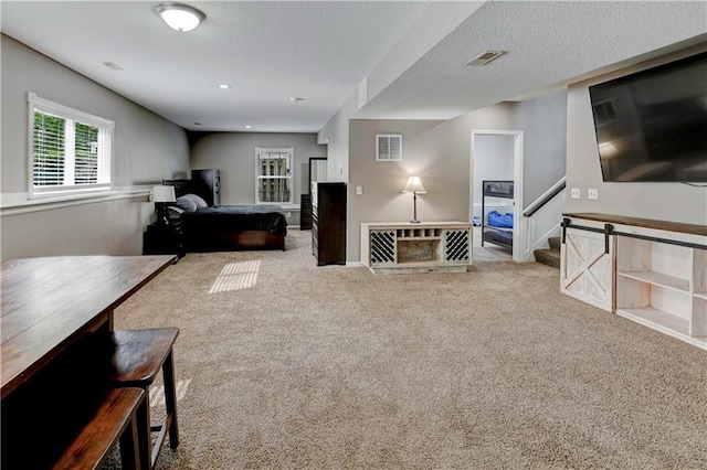 carpeted living room featuring visible vents, stairs, and baseboards