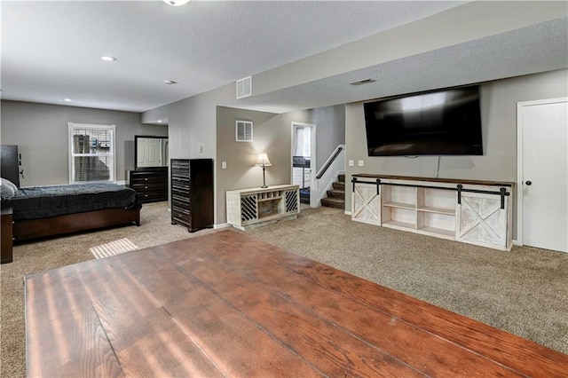 carpeted bedroom with a textured ceiling and visible vents
