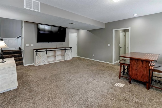 interior space featuring stairway, visible vents, baseboards, and carpet