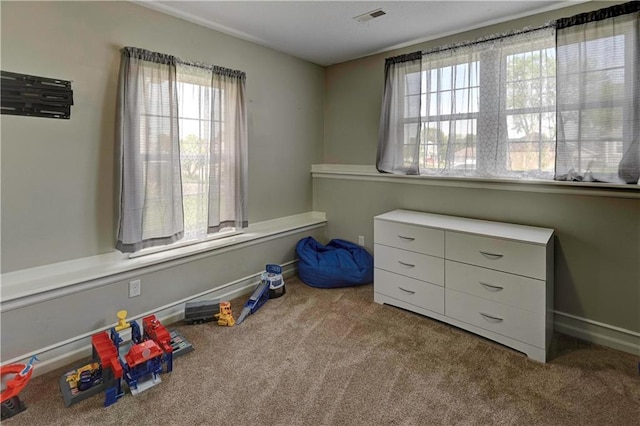 game room featuring plenty of natural light, carpet, baseboards, and visible vents
