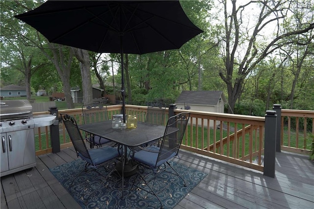 wooden terrace featuring an outdoor structure, a storage shed, and outdoor dining area