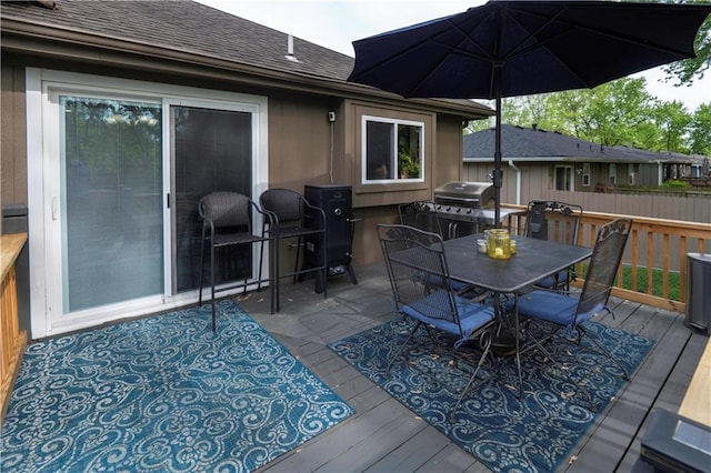 deck with fence, outdoor dining area, and a grill