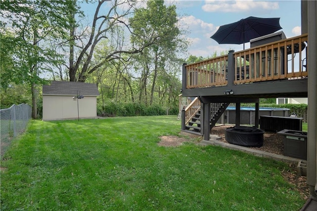view of yard with an outdoor structure, fence, a deck, stairs, and a storage shed
