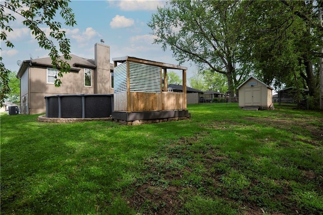 view of yard with an outdoor structure, central air condition unit, a storage shed, and a pool