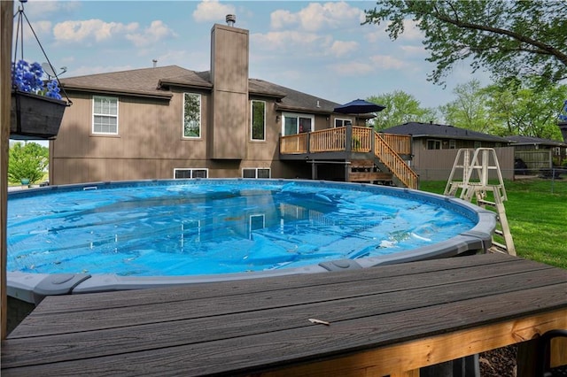 pool with fence, stairs, and a deck