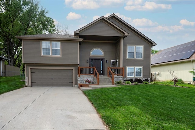 split foyer home with a garage, driveway, and a front lawn