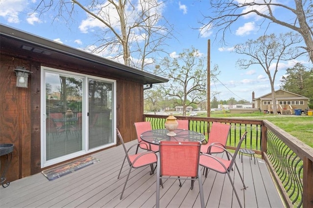 wooden deck featuring a yard and outdoor dining space