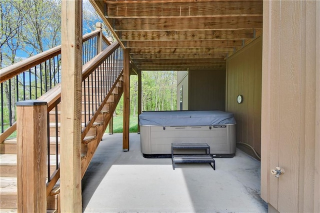 view of patio featuring stairway and a hot tub