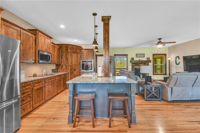 kitchen featuring open floor plan, light wood-style flooring, and stainless steel appliances