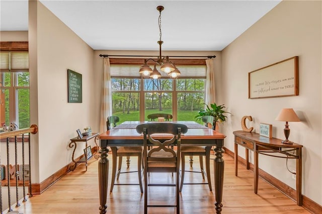 dining space with baseboards, plenty of natural light, and light wood-type flooring