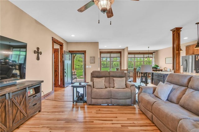 living room featuring baseboards, recessed lighting, ceiling fan, and light wood-style flooring