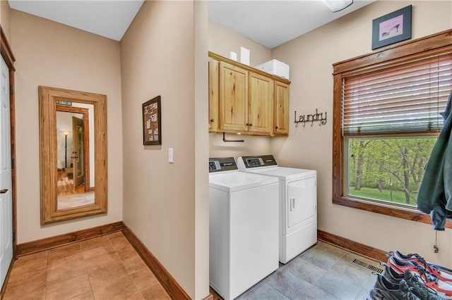 laundry area with separate washer and dryer, baseboards, cabinet space, and visible vents