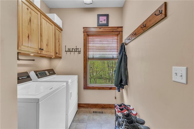 laundry room featuring cabinet space, light tile patterned floors, baseboards, and washer and clothes dryer