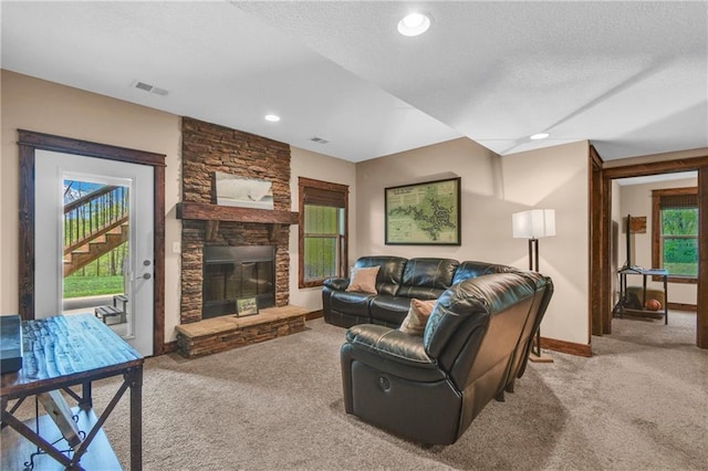 living room featuring a fireplace, baseboards, carpet, and visible vents