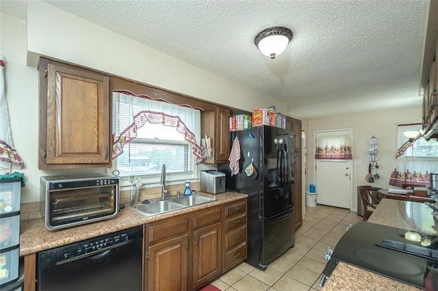 kitchen with light countertops, light tile patterned floors, a sink, black appliances, and a textured ceiling