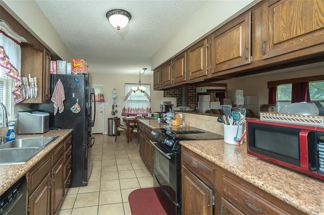 kitchen with light tile patterned flooring, a wealth of natural light, a sink, and black appliances