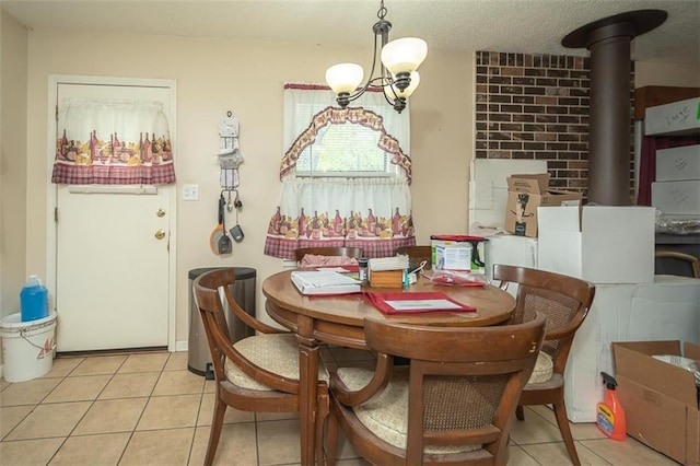 dining area featuring a wood stove, a notable chandelier, and light tile patterned floors