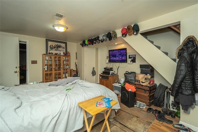 bedroom featuring wood finished floors and visible vents