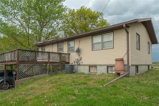 back of property with a lawn, central AC unit, and a deck