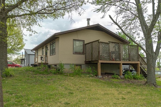 view of home's exterior with a yard, stairs, and a deck