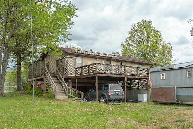 back of house with a wooden deck, stairway, and a yard