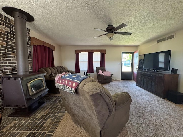 8833 Hickory Ln, Ozawkie, KS 66070 - living room with a wood stove, ceiling fan, a textured ceiling, and carpet flooring