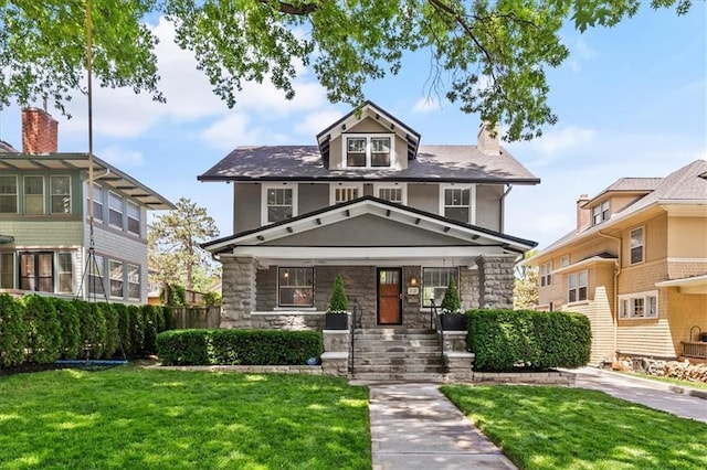 12 E 57th St, Kansas City, MO 64113 - american foursquare style home featuring stone siding, a front yard, a porch, and stucco siding