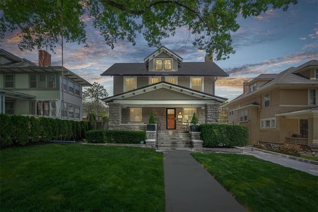 12 E 57th St, Kansas City, MO 64113 - traditional style home with a front yard, stone siding, and a porch