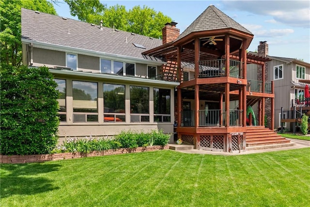 3610 NE Basswood Dr, Lees Summit, MO 64064 - back of house featuring a chimney, a lawn, stucco siding, and roof with shingles