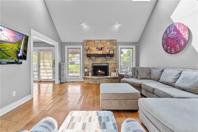 3610 NE Basswood Dr, Lees Summit, MO 64064 - living room with high vaulted ceiling, a fireplace, light wood finished floors, and baseboards