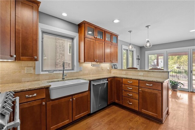 3610 NE Basswood Dr, Lees Summit, MO 64064 - kitchen with a sink, stainless steel dishwasher, a peninsula, light wood-type flooring, and decorative backsplash