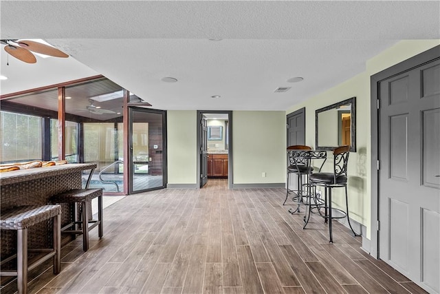3610 NE Basswood Dr, Lees Summit, MO 64064 - dining room featuring ceiling fan, light wood-style floors, baseboards, and a textured ceiling