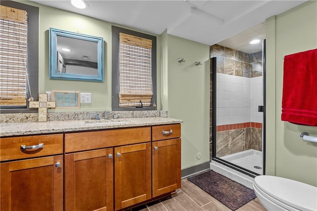 3610 NE Basswood Dr, Lees Summit, MO 64064 - full bathroom with a stall shower, vanity, toilet, wood finished floors, and recessed lighting