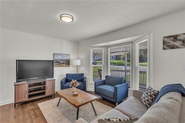 living area with baseboards and dark wood finished floors