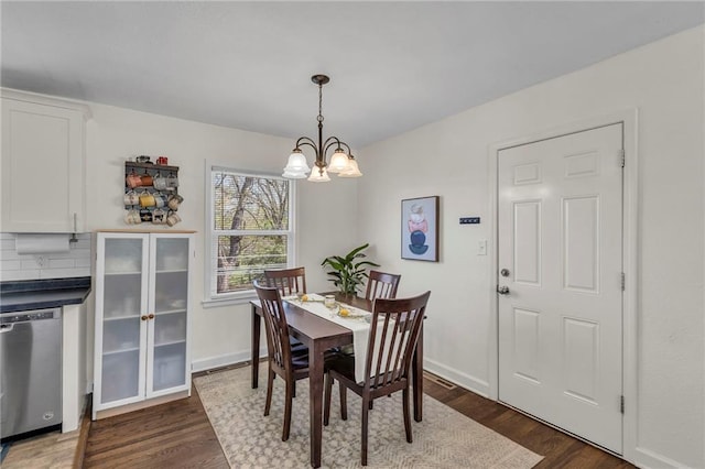 dining room featuring baseboards, dark wood-type flooring, and a notable chandelier