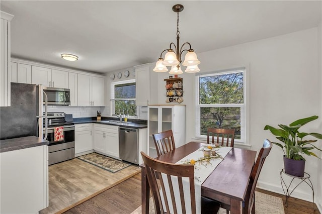 kitchen featuring a sink, white cabinetry, dark countertops, and stainless steel appliances