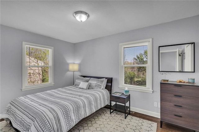 bedroom with baseboards and wood finished floors