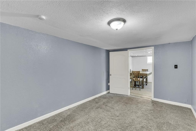 unfurnished room with baseboards, carpet, and a textured ceiling