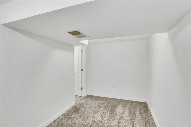 basement with visible vents, baseboards, and light carpet