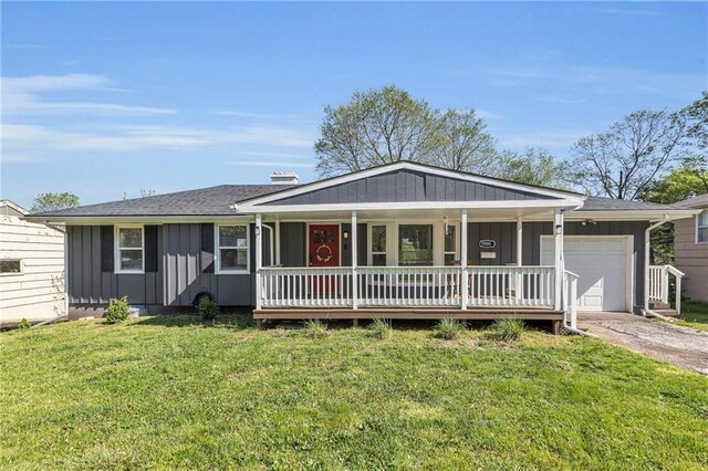 ranch-style home featuring a front lawn, a garage, board and batten siding, a porch, and driveway