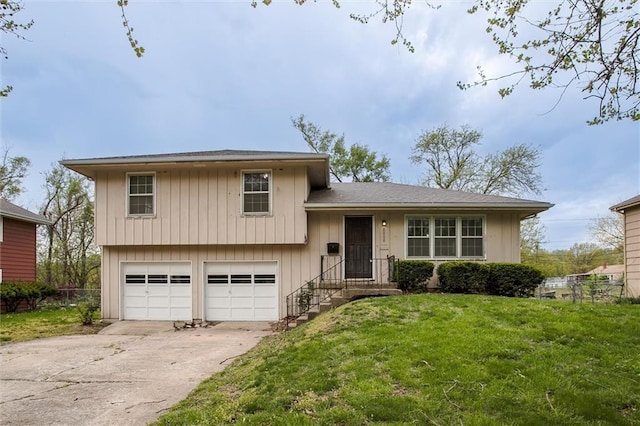 tri-level home featuring driveway, fence, a front lawn, and an attached garage