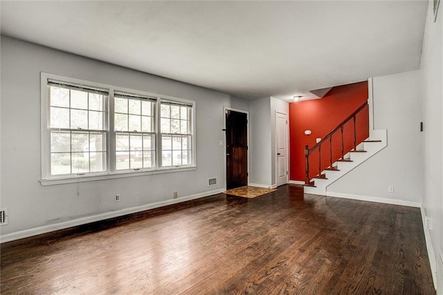 interior space with wood finished floors, plenty of natural light, baseboards, and stairs